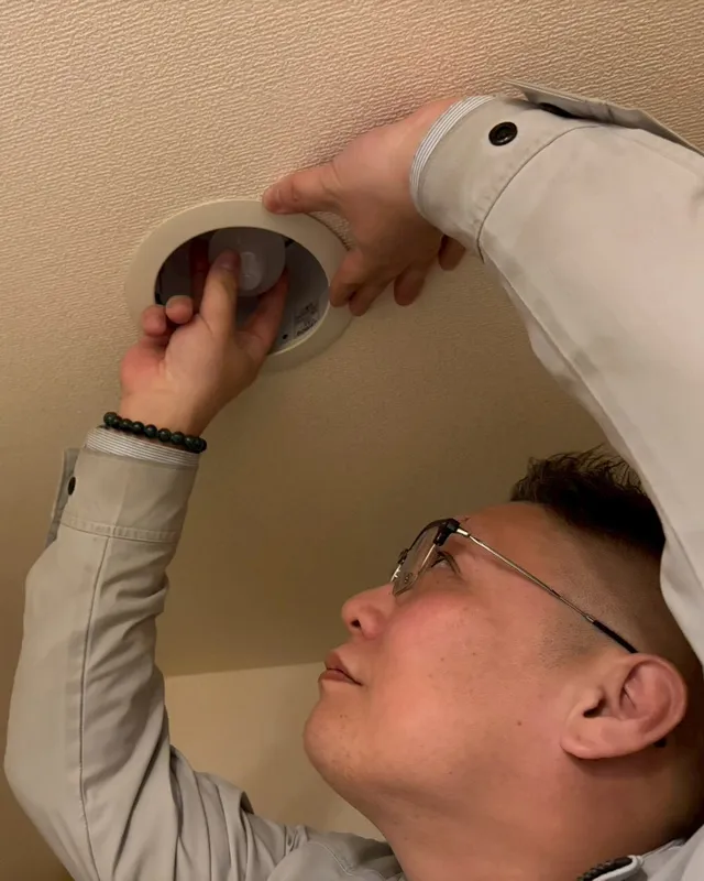 照明の取り付け作業をする職人